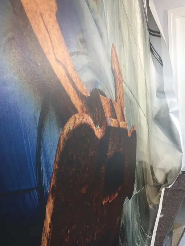 Close-up van fotobehang met een scheepsanker, de laatste baan wordt nog op zijn plek gebracht